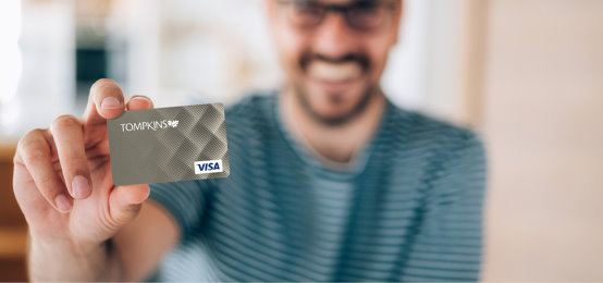 man holding tompkins credit card